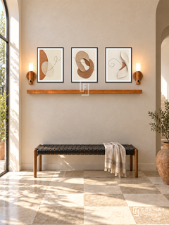FREMAT Earth And Thread shelf set with three 30 x 40 cm black frames, 2 cm white borders, honey wood shelf and two warm sensor lamps. Morning Mediterranean modern foyer, sandy plaster wall, black woven leather bench, pale checkerboard limestone floor, terracotta pot far right, sunlit tall doorway far left.