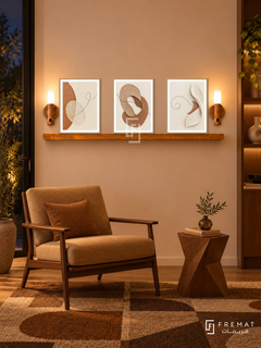 FREMAT Earth And Thread shelf set with three 30 x 40 cm wooden texture frames, 2 cm white borders, honey wood shelf and two warm sensor lamps. Night mid-century earth-tone reading nook, pale apricot wall, walnut framed lounge chair with camel upholstery, angular wood side table, geometric brown rug, dark glass doorway left.
