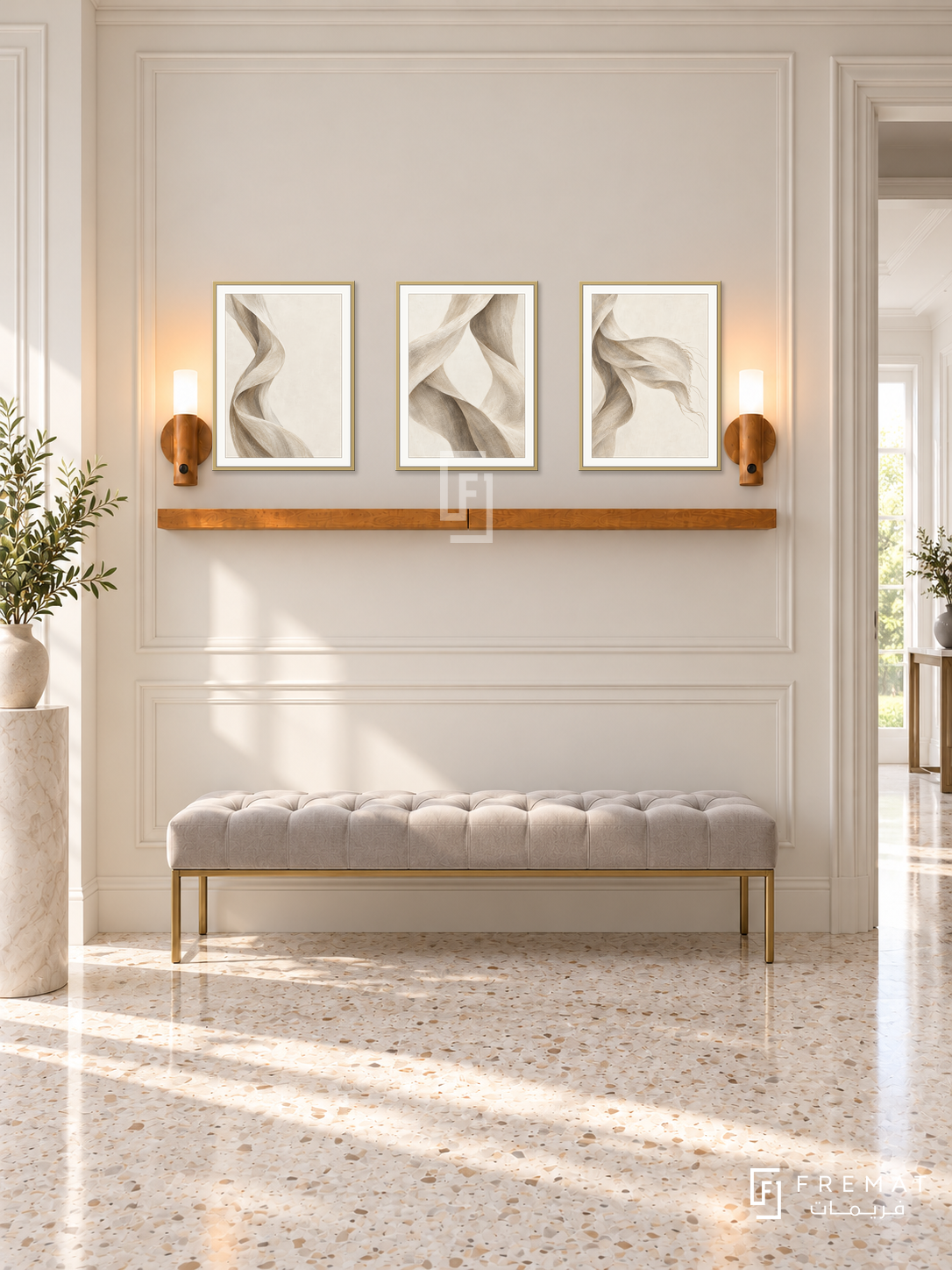 FREMAT Linen Wind shelf set with three 30 x 40 cm gold frames, 2 cm white borders, honey wood shelf and two warm sensor lamps. Morning soft neoclassical hallway, cream wall with wide mouldings, pale grey tufted bench with brass legs, ivory terrazzo floor, bright doorway right, ceramic pedestal far left.