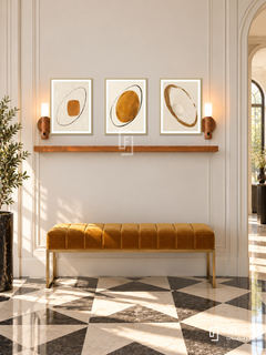 FREMAT Ochre Orbit shelf set with three 30 x 40 cm gold frames, 2 cm white borders, honey wood shelf and two warm sensor lamps. Morning sophisticated art-deco hallway, pale cream wall with vertical mouldings, mustard velvet bench on brass legs, black and ivory geometric stone floor, sunlit opening right.