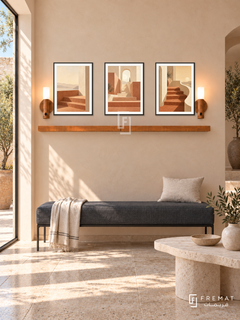 FREMAT Terrace Of Light shelf set with three 30 x 40 cm black frames, 2 cm white borders, honey wood shelf and two warm sensor lamps. Morning modern Mediterranean reception, pale apricot plaster wall, charcoal linen bench with slim steel base, asymmetric limestone table, travertine floor, tall sunlit doorway on left.