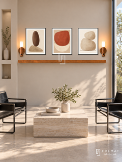 FREMAT Earthen Balance shelf set with three 30 x 40 cm black frames, 2 cm white borders, honey wood shelf and two warm sensor lamps. Morning minimalist reception with clay beige wall, black leather sling chairs, square light travertine table, pale concrete floor, wide sunny window right and shallow rectangular niche left.