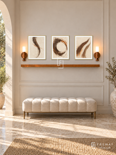 FREMAT Sand Script shelf set with three 30 x 40 cm gold frames, 2 cm white borders, honey wood shelf and two warm sensor lamps. Morning refined Mediterranean hall, pale sand panelled wall, cream tufted bench with bronze feet, travertine floor, sunny arch left, dry branch vase far right.