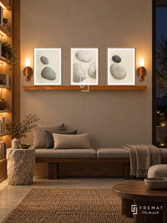 FREMAT Pebble Garden shelf set with three 30 x 40 cm wooden texture frames, 2 cm white borders, honey wood shelf and two warm sensor lamps. Night wabi sabi library, taupe plaster wall, low walnut bench with grey linen cushions, rough stone side table, woven rug, dark window right, illuminated oak bookcase left.