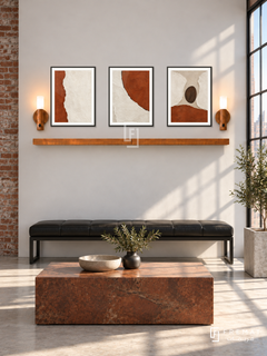FREMAT Rust And Chalk shelf set with three 30 x 40 cm black frames, 2 cm white borders, honey wood shelf and two warm sensor lamps. Morning urban industrial reception, chalk white wall with exposed brick at left edge, black leather bench, rectangular rust coloured stone table, pale concrete floor, sunny factory window right.