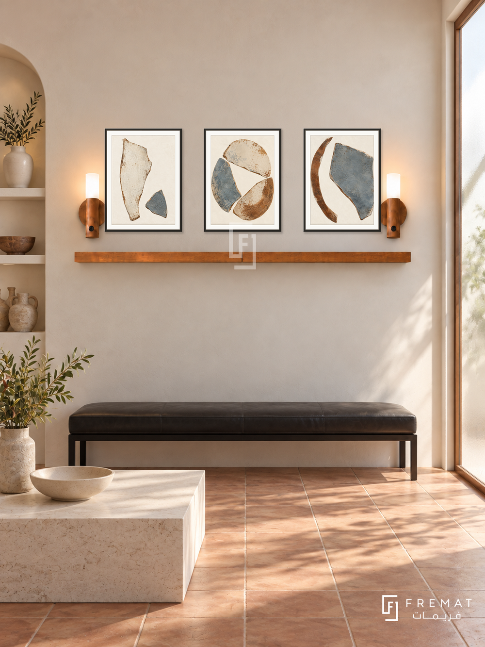 FREMAT Ceramic Fragments shelf set with three 30 x 40 cm black frames, 2 cm white borders, honey wood shelf and two warm sensor lamps. Morning minimalist ceramic studio reception, warm ivory plaster wall, black low leather bench, monolithic off-white stone table, terracotta tiled floor, sunny frosted glass doorway right, ceramics in left alcove.