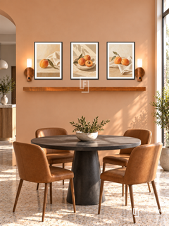 FREMAT Sunlit Apricot shelf set with three 30 x 40 cm black frames, 2 cm white borders, honey wood shelf and two warm sensor lamps. Morning contemporary breakfast alcove, apricot plaster wall, charcoal round pedestal table and caramel chairs, pale terrazzo, sunny narrow window right, open doorway left.