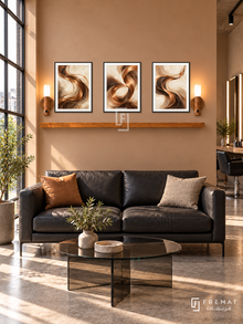 FREMAT Copper Waves shelf set with three 30 x 40 cm black frames, 2 cm white borders, honey wood shelf and two warm sensor lamps. Morning urban hair studio lounge, warm copper beige wall, black leather two seat sofa, round smoked glass table, concrete floor, large sunlit factory window left, styling counter far right.
