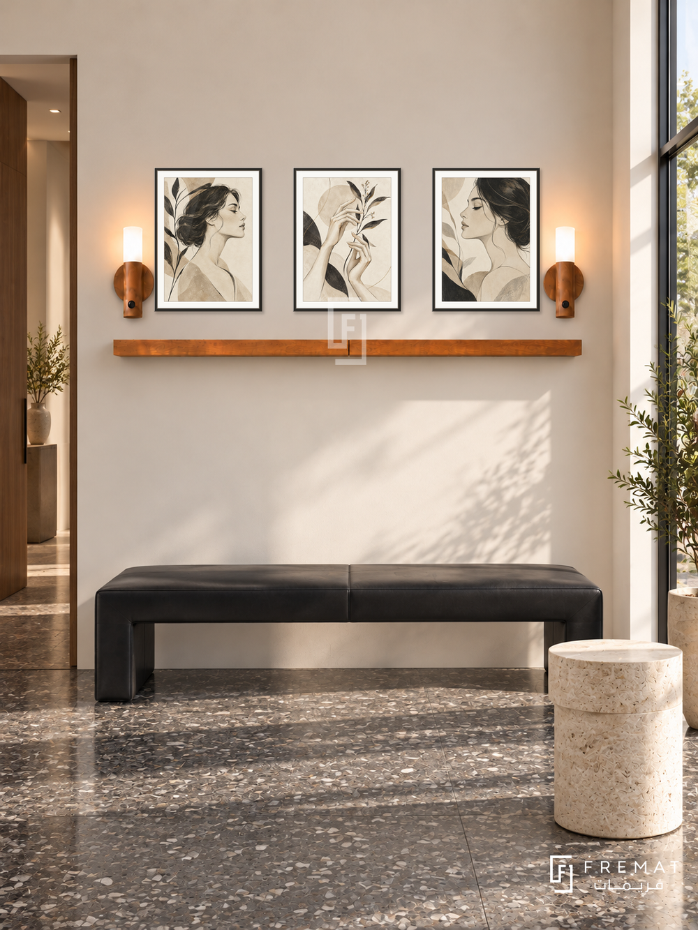 FREMAT Contour Muse shelf set with three 30 x 40 cm black frames, 2 cm white borders, honey wood shelf and two warm sensor lamps. Morning architectural beauty studio, warm ivory wall, black angular leather bench, pale cylindrical stone table, charcoal terrazzo floor, bright shopfront right, slim doorway left.