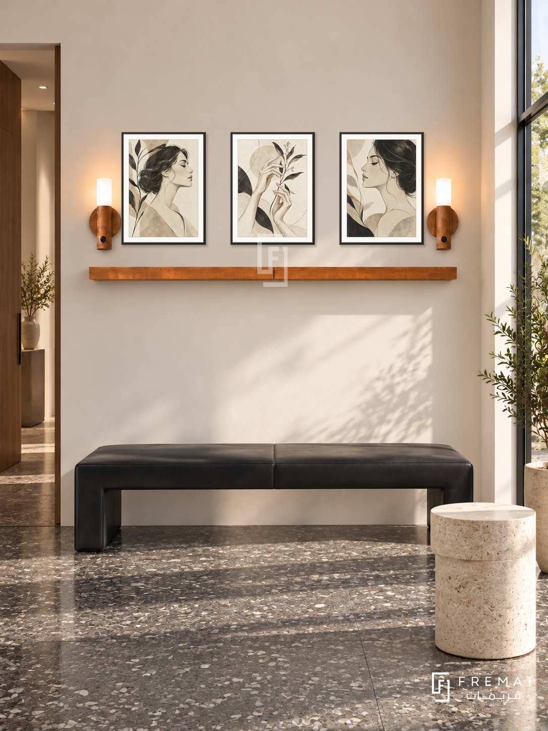FREMAT Contour Muse shelf set with three 30 x 40 cm black frames, 2 cm white borders, honey wood shelf and two warm sensor lamps. Morning architectural beauty studio, warm ivory wall, black angular leather bench, pale cylindrical stone table, charcoal terrazzo floor, bright shopfront right, slim doorway left.