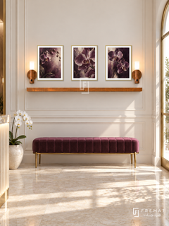 FREMAT Velvet Orchid shelf set with three 30 x 40 cm gold frames, 2 cm white borders, honey wood shelf and two warm sensor lamps. Morning elegant spa reception, ivory panelled wall, plum velvet bench with golden legs, pale stone floor, sunny door right, subtle brass trim and single orchid low left.