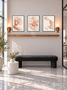 FREMAT Satin Petals shelf set with three 30 x 40 cm black frames, 2 cm white borders, honey wood shelf and two warm sensor lamps. Morning minimalist nail studio waiting space, pale blush grey wall, black upholstered bench and small white drum table, grey terrazzo floor, bright window left, black framed glass partition far right.