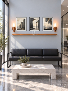 FREMAT Shared Horizon shelf set with three 30 x 40 cm black frames, 2 cm white borders, honey wood shelf and two warm sensor lamps. Morning contemporary corporate reception, pale blue grey wall, black leather waiting bench, rectangular white stone table, polished grey floor, sunlit glass entrance left, glass meeting room far right.