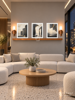 FREMAT Shared Horizon shelf set with three 30 x 40 cm white frames, 2 cm white borders, honey wood shelf and two warm sensor lamps. Night modern coworking lobby, warm grey wall, white modular seating and oak round table, pale terrazzo floor, dark city windows right, luminous ceiling slots.