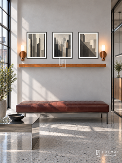 FREMAT Urban Order shelf set with three 30 x 40 cm black frames, 2 cm white borders, honey wood shelf and two warm sensor lamps. Morning industrial architecture studio reception, smooth pale cement display wall, oxblood leather bench, chrome rectangular side table, grey terrazzo floor, bright steel factory window at left, glass partition at right.