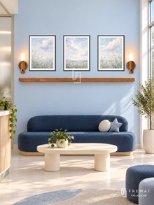 FREMAT Cloud Garden shelf set with three 30 x 40 cm black frames, 2 cm white borders, honey wood shelf and two warm sensor lamps. Morning modern pediatric clinic quiet waiting area, very pale sky blue display wall, navy rounded bench, cream oval table, pale seamless floor, sunny tall window right, frosted partition left, sophisticated calm design.