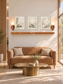 FREMAT Sand And Stone shelf set with three 30 x 40 cm gold frames, 2 cm white borders, honey wood shelf and two warm sensor lamps. Morning elegant wellness clinic lounge, cream plaster display wall, caramel compact settee, small brass oval table, pale parquet, sunny glazing right, fluted partition left.