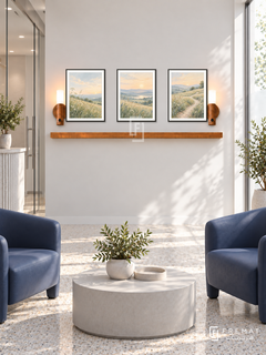 FREMAT New Light shelf set with three 30 x 40 cm black frames, 2 cm white borders, honey wood shelf and two warm sensor lamps. Morning bright modern medical reception, off-white display wall, two navy wipe-clean chairs, rounded pale grey table, light terrazzo, tall frosted sunny window right, glass door left.