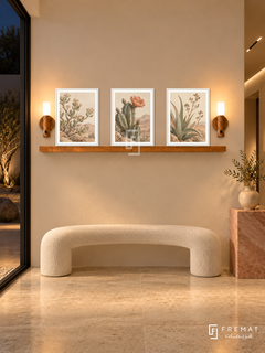 FREMAT Desert Bloom shelf set with three 30 x 40 cm white frames, 2 cm white borders, honey wood shelf and two warm sensor lamps. Night minimalist desert villa corridor, warm ivory wall, curved white bench, pink sandstone pedestal, cream limestone floor, dark courtyard left, recessed linear ceiling lights.