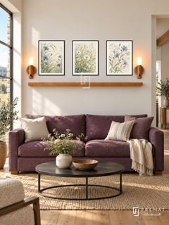 FREMAT Wildflower Meadow shelf set with three 30 x 40 cm black frames, 2 cm white borders, honey wood shelf and two warm sensor lamps. Morning contemporary country lounge, soft ivory wall, plum linen sofa, black round coffee table, oak floor, meadow view through window left, broad doorway right.