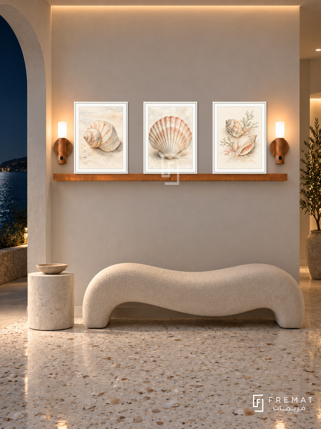 FREMAT Tidal Shells shelf set with three 30 x 40 cm white frames, 2 cm white borders, honey wood shelf and two warm sensor lamps. Night coastal foyer, chalk plaster wall, cream wave-shaped bench, white cylindrical side table, shell terrazzo floor, dark sea through arch left, warm ceiling strip.