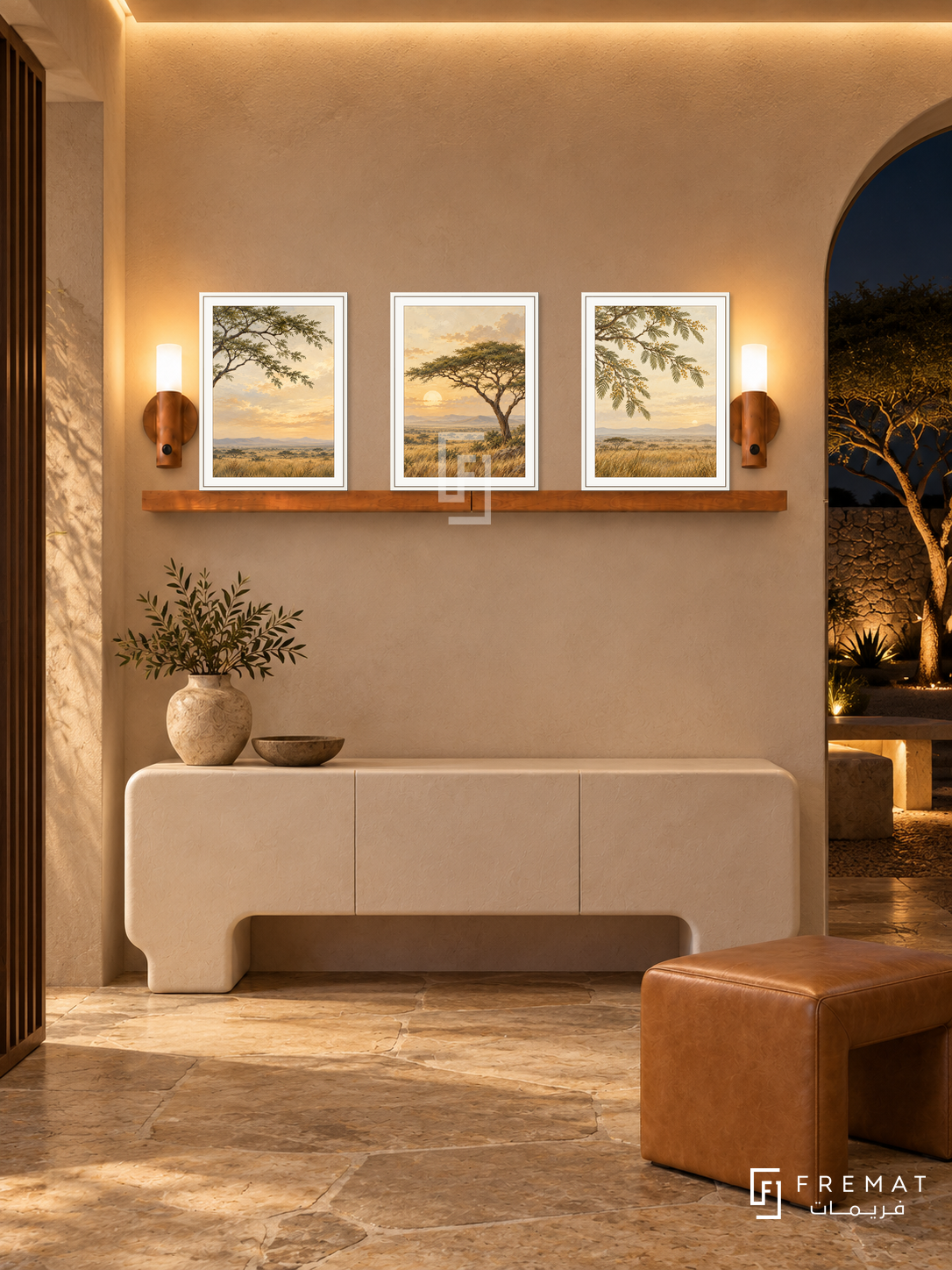 FREMAT Acacia Horizon shelf set with three 30 x 40 cm white frames, 2 cm white borders, honey wood shelf and two warm sensor lamps. Night modern safari foyer, sand plaster, white sculpted credenza, tan leather stool, stone floor, dark courtyard with acacia tree through arch right, warm ceiling illumination.