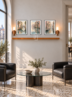 FREMAT Venetian Reflections shelf set with three 30 x 40 cm black frames, 2 cm white borders, honey wood shelf and two warm sensor lamps. Morning Venetian modern apartment, pale stone wall, black leather chairs, glass oval table, terrazzo floor, canal-view arched window left, tall double doorway right.