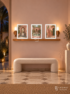FREMAT Marrakech Rose shelf set with three 30 x 40 cm white frames, 2 cm white borders, honey wood shelf and two warm sensor lamps. Night Moroccan contemporary foyer, pale blush wall, sculptural ivory bench, white pedestal, patterned stone floor, dark palm courtyard left, warm hidden lighting.