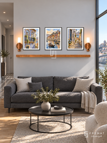 FREMAT Porto Tiles shelf set with three 30 x 40 cm black frames, 2 cm white borders, honey wood shelf and two warm sensor lamps. Morning Porto modern apartment, pale grey wall, charcoal sofa, black metal round table, oak floor, tall river window right, tiled hallway left.