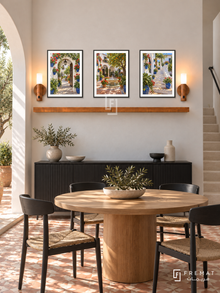 FREMAT Andalusian Patios shelf set with three 30 x 40 cm black frames, 2 cm white borders, honey wood shelf and two warm sensor lamps. Morning Andalusian contemporary dining room, white stucco wall, black sideboard below shelf, round oak table and black chairs, patterned terracotta floor, courtyard arch left, slim stone stair right.