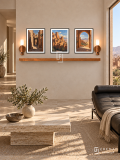FREMAT Desert Kasbah shelf set with three 30 x 40 cm black frames, 2 cm white borders, honey wood shelf and two warm sensor lamps. Morning contemporary desert retreat, pale clay wall, black leather chaise, low travertine table, sand stone floor, kasbah landscape window right, angular corridor left.