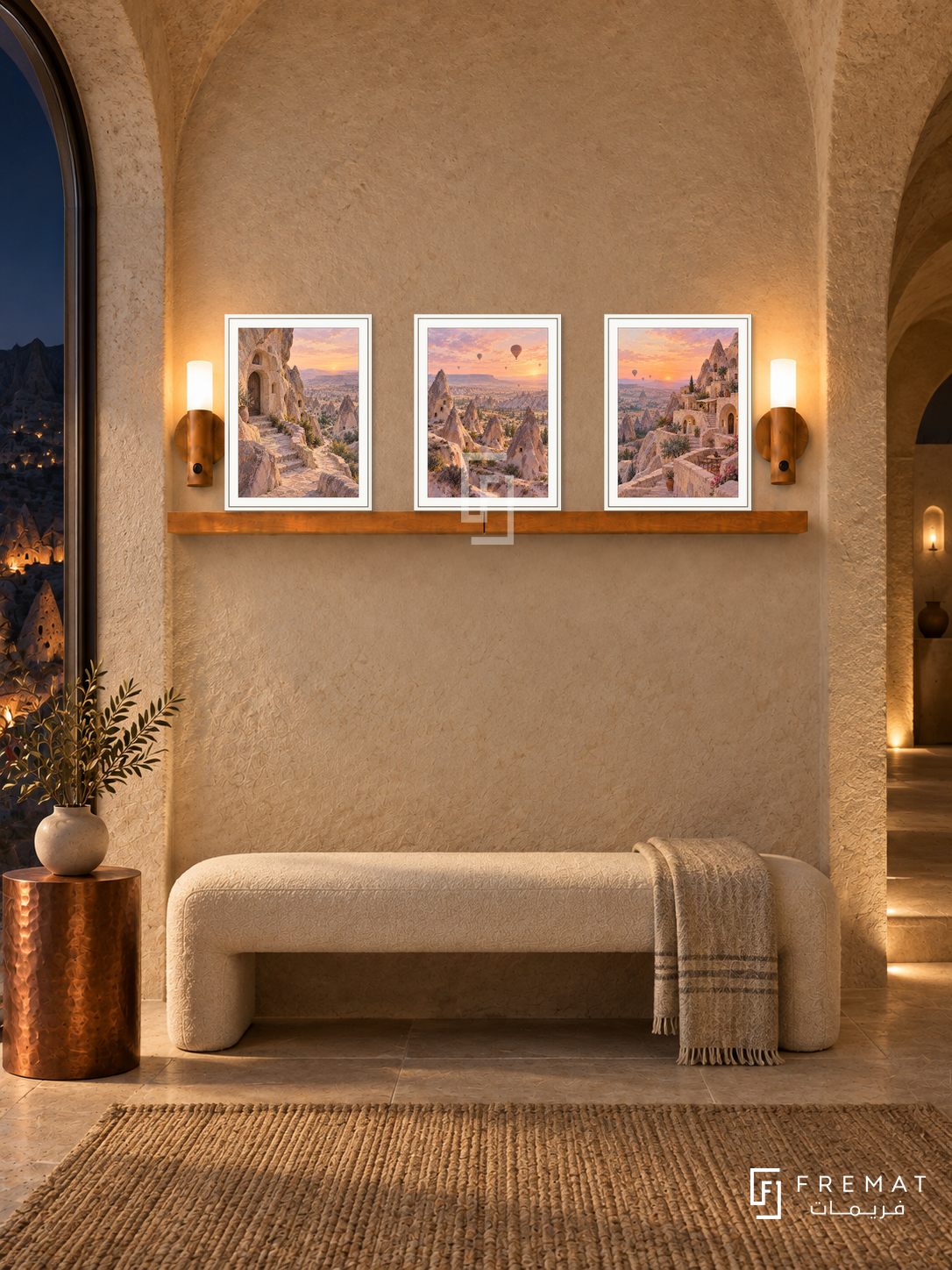 FREMAT Cappadocia Dawn shelf set with three 30 x 40 cm white frames, 2 cm white borders, honey wood shelf and two warm sensor lamps. Night Cappadocian boutique suite entrance, pale sandy arched stone walls, ivory upholstered bench, copper side pedestal, dark valley through tall side window.