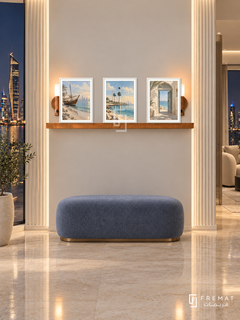 FREMAT Kuwait Seaside shelf set with three 30 x 40 cm white frames, 2 cm white borders, honey wood shelf and two warm sensor lamps. Night Kuwait luxury entry, ivory fluted wall edges and smooth centre, curved white console, blue grey ottoman, polished limestone floor and city skyline.