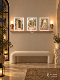FREMAT Levantine Stone shelf set with three 30 x 40 cm white frames, 2 cm white borders, honey wood shelf and two warm sensor lamps. Night Levantine entrance courtyard room, cream plaster, white boucle bench, carved limestone pedestal, arched black window and garden lanterns.