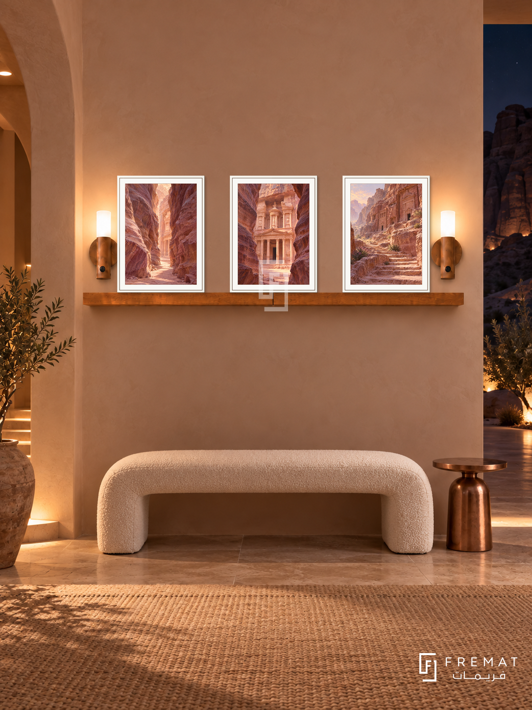 FREMAT Petra Rose shelf set with three 30 x 40 cm white frames, 2 cm white borders, honey wood shelf and two warm sensor lamps. Night Jordanian desert villa foyer, blush sand arched walls, white boucle bench, copper side table, dark cliff view through narrow opening.