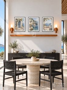 FREMAT Island Retreat shelf set with three 30 x 40 cm black frames, 2 cm white borders, honey wood shelf and two warm sensor lamps. Morning island contemporary villa dining room, white lime wall, black timber buffet, pale round stone table, black woven chairs, turquoise sea through tall side glass.