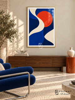 Cobalt Current: An ivory ribbon winds through cobalt and deep navy fields beside a vivid vermilion disc. Gold PVC frame displayed with a walnut sideboard and blue lounge chair.
