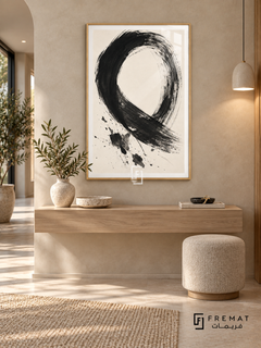 Monochrome Gesture: A sweeping black brushstroke forms an open loop on warm ivory, with dry-brush marks and scattered ink-like splashes. Wooden Texture PVC frame displayed with a floating oak console and boucle stool.