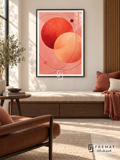 Coral Orbit: Overlapping coral-red and apricot circles float on blush pink, crossed by fine burgundy orbital curves and two small dots. Black PVC frame displayed with a cushioned walnut window bench.