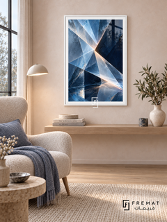 Glacial Prism: Angular translucent facets in ice blue, slate and deep navy converge around pale luminous seams, creating a crystalline illusion. White PVC frame displayed with a cream chair and floating oak shelf.
