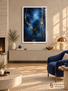 Midnight Vein: Luminous blue clouds emerge from deep navy and near-black textures, crossed by fine sweeping gold-colored veins and flecks. White PVC frame displayed with a cream cabinet beside a stone fireplace and blue armchair.