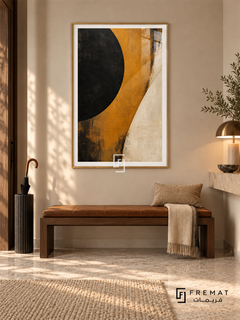 Ochre Eclipse: A large cropped black disc meets a sweeping ochre band and an ivory field, with weathered painterly textures and dark scuffed edges. Gold PVC frame displayed with a walnut entry bench with a leather cushion.