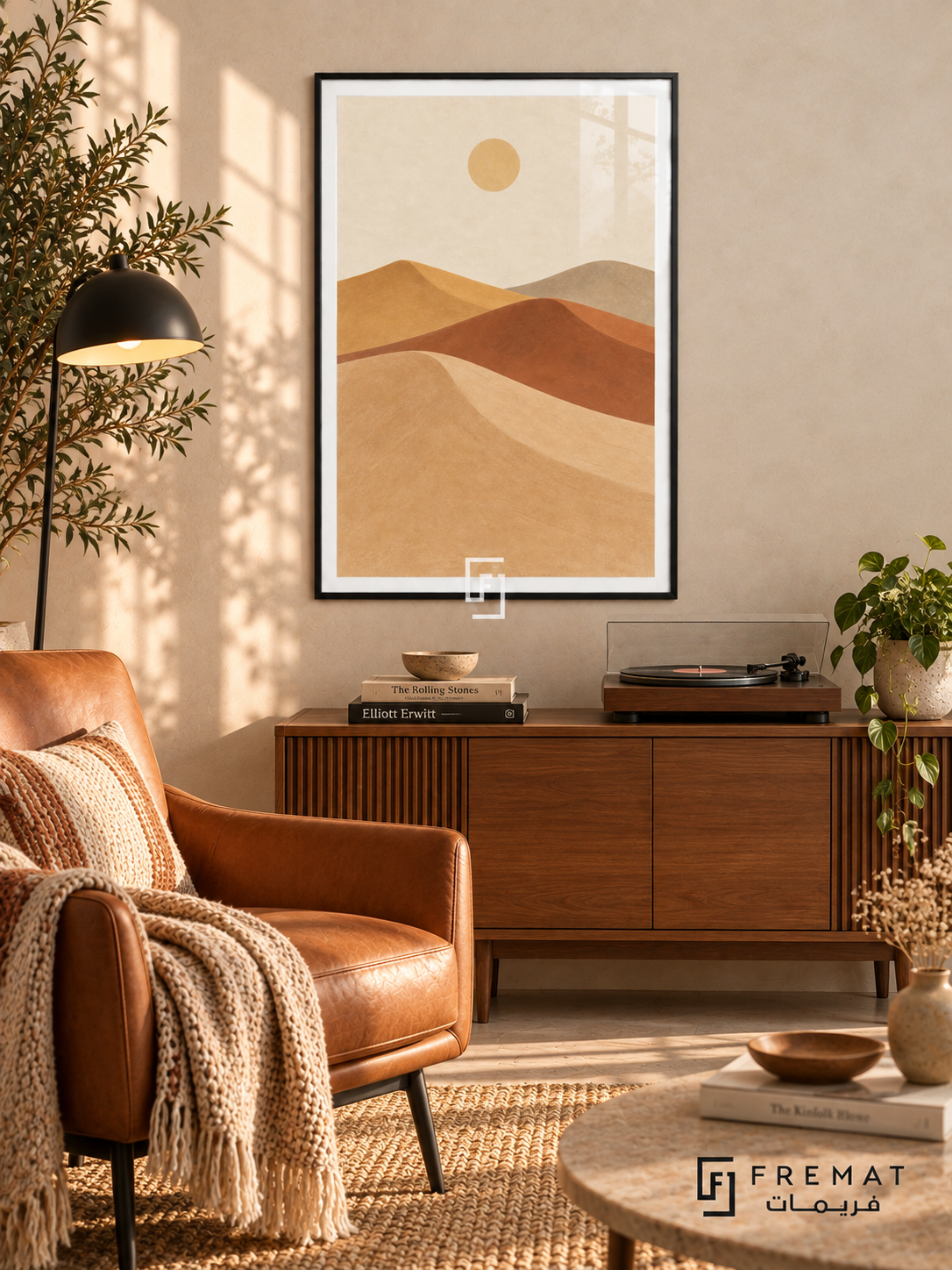 Desert Dunes. Sweeping layers of sand, clay, ochre and taupe dunes sit beneath a small pale sun. Shown in a Black PVC frame in a styled room.