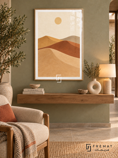 Desert Dunes. Sweeping layers of sand, clay, ochre and taupe dunes sit beneath a small pale sun. Shown in a Wooden Texture PVC frame in a styled room.