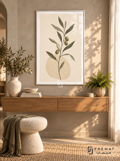 Olive Branch. A slender branch with olive-green leaves and dark olives rises above a pale oval on ivory. Shown in a White PVC frame in a styled room.