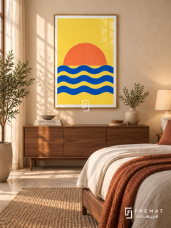 Cobalt Sunrise. An orange half-sun rises above three cobalt wave bands on a vivid yellow background. Shown in a Gold PVC frame in a styled room.