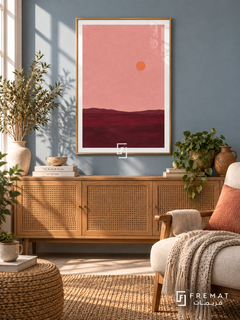Pink Horizon. A small orange sun floats above a low burgundy horizon beneath a dusty pink sky. Shown in a Gold PVC frame in a styled room.