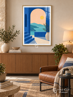 Blue Arch View. A cobalt arch and steps frame turquoise water, distant hills and a yellow sun, with a potted leafy branch. Shown in a Gold PVC frame in a styled room.