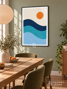 Blue Tide. Three flowing navy, turquoise and pale blue wave bands sit below an orange sun in an ivory sky. Shown in a Black PVC frame in a styled room.