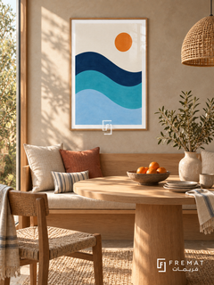 Blue Tide. Three flowing navy, turquoise and pale blue wave bands sit below an orange sun in an ivory sky. Shown in a Wooden Texture PVC frame in a styled room.